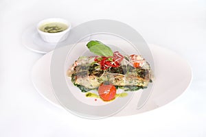 HERB CRUSTED HAMOUR FILLET with sauce served in dish isolated on table top view of arabic food