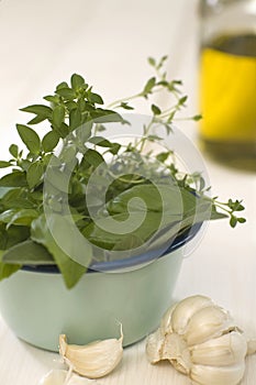 Herb-flavored oil and various herbs in bowl