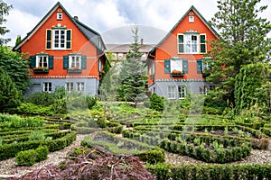 Herb garden with herb beds in front of colorful children`s playhouses of Hotel Bareiss in Baiersbronn, Black Forest, Germany