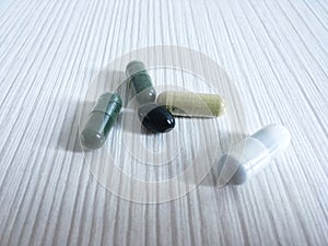 Herb powder in capsules several kinds on wooden background.