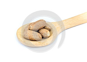 Nutmeg on wooden spoon over white background. photo