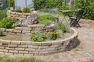 Herb spiral in the garden with herbs and flowers