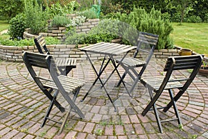 Herb spiral in the garden and table with chairs