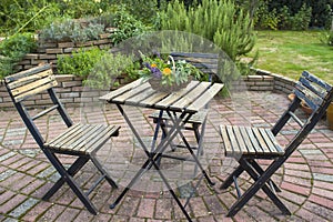 Herb spiral in the garden and table with chairs