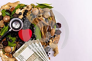Herbal black tablets, stethoscope, money bills and heart shape with spices on white background