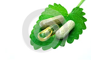 Herbal capsules on melisa leaf photo