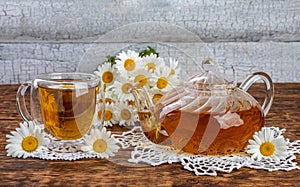 herbal chamomile tea and flowers. teapot and tea glass