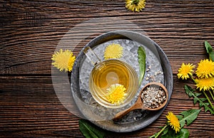Herbal drink for liver detox, dandelion root tea in a glass cup decorated with fresh flowers with copy space photo