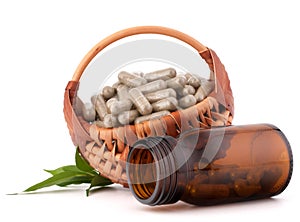 Herbal drug capsules in wicker basket. Alternative medicine concept.