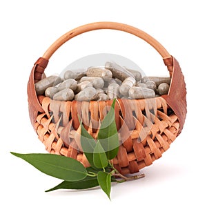 Herbal drug capsules in wicker basket. Alternative medicine concept.