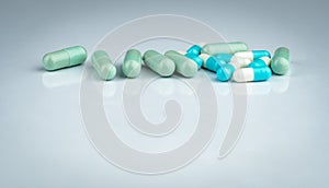 Herbal and drug interactions. Green and blue capsule pill on white background. Herbal medicine. Pharmaceutical industry. Pharmacy