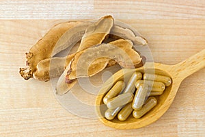 Herbal Lingzhi medicine in capsule next to sliced dried Reishi.