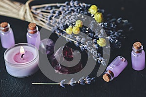 Herbal magick in wicca and witchcraft using lavender infused water. Purple candle, amethyst pyramid crystal, dried lavender flower photo