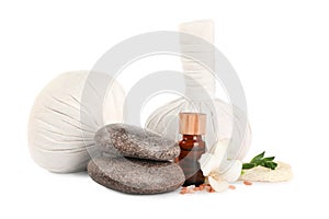 Herbal massage bags and other spa products on white background