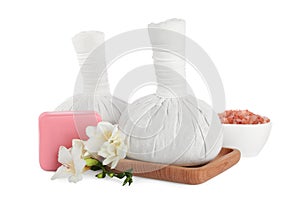 Herbal massage bags, soap, flowers and sea salt on white background. Spa procedure