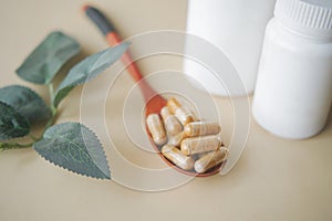 herbal medicine capsule on a wooden spoon