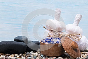 Herbal sacs and stones for massage and spa on a blue background