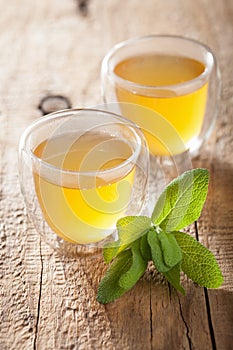 Herbal sage tea with green leaf in glass cup