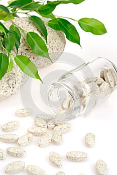 Herbal supplement pills spilling out of bottle photo