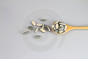 Herbal Supplement vitamin pills or tablets in wooden spoon