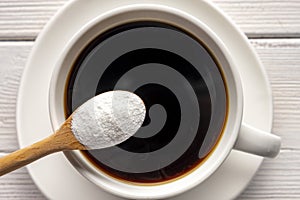 Herbal sweetener stevia in spoon and a cup of coffee