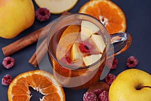 Herbal tea with apple, ginger, lemon, cinnamon and thyme in a glass. Warming tea, healthy fruit infused tea. Horizontal