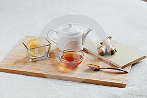 Herbal tea with chamomile flowers, turmeric and honey on a wooden board. Treatment of hot drink ginger. folk remedies