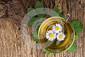 Herbal tea with chamomile on old wooden table. Top view. alternative medicine concept