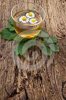 Herbal tea with chamomile on old wooden table. Top view. alternative medicine concept