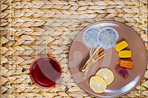 Herbal tea with cinnamon and lemon on a wicker basket. Christmas cones photo