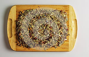 Herbal tea with dried fruits and dried flowers. Background of tea on a kitchen wooden board