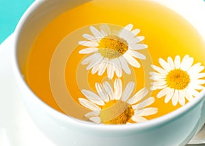 Herbal tea with fresh chamomile flowers in a cup