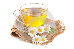Herbal tea with fresh chamomile flowers on sackcloth isolated on white background