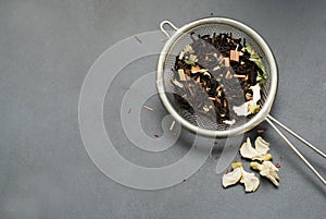 Herbal Acaccia Tea Healthy Drink in bowl and sieve over Black Background copy space. Healthy Drink, coldness.