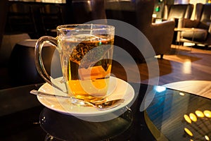 Herbal tea infusing in a glass mug at night with copy space