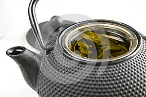 Herbal tea, iron teapot and cup of tea on the white background, chinese traditional tea serving