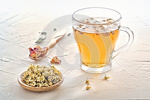 Herbal tea with pharmaceutical chamomile on a white table