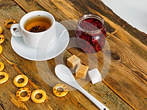 Herbal tea, raspberry jam and bagels on an old wooden table