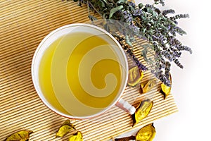 Herbal tea in red cup, dry marjoram herbs on