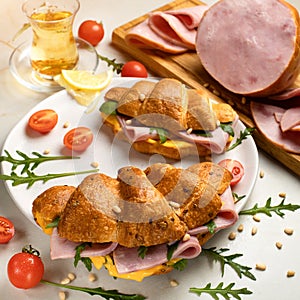 Herbal tea and two Croissant sandwich with hamon and chees on plate. Morning breakfast. White backgrounds