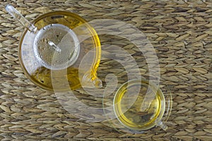 Herbaltea in a Teapot and Teaglas on natural background