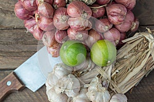 Herbs garlic, lemon and knife on wood