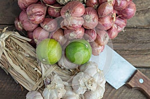 Herbs garlic, lemon and knife on wood