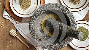 Herbs in a Mortar and Pestle with Rustic Plates of Dried Herbs