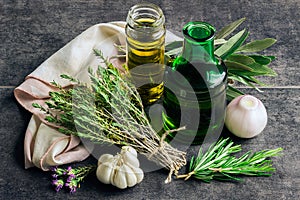Herbs: rosemary, thyme, bottles of olive oil and garlic