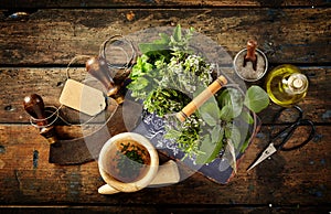 Herbs, scissors and mezzaluna over rustic table photo