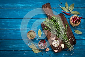 Herbs and spices at blue wooden table.