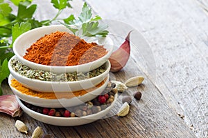 Herbs and spices in bowls on wooden boards background