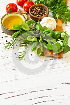 Herbs spices, olive oil and vegetables on a wooden table. Copy space