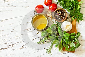 Herbs spices, olive oil and vegetables on a wooden table. Top view flat lay background